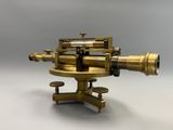 un télescope ancien en laiton posé sur un socle, sur fond blanc