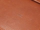 a close up of a brown leather bag with a zipper