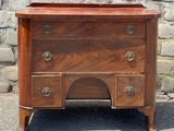 une petite commode posée sur le trottoir