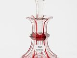 an image of a red glass decanter sitting on top of a white surface