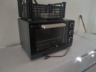 a black microwave sitting on a counter with a basket on top of it
