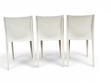 three white chairs sitting next to each other on a white surface