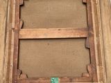 an old wooden picture frame with a green label on it