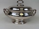 a silver bowl with a lid on a white table