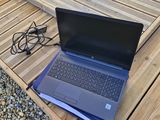 a laptop computer sitting on a wooden table on the ground