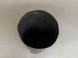 a black cup that is sitting on a white table