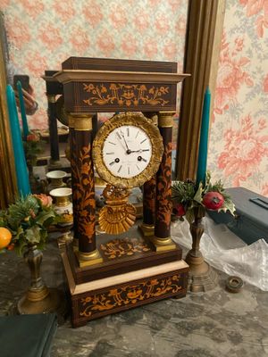 a clock that is sitting on a table in front of a mirror