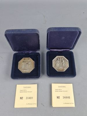 Deux médailles d'or se trouvent dans une boîte violette posée sur une table