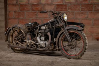 a old motorcycle that is parked in front of a brick wall