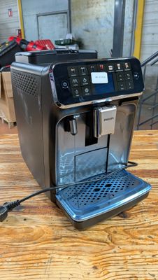 une machine à expresso posée sur une table en bois dans une pièce