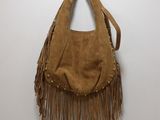 a brown purse hanging on a wall with a hook