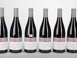six bouteilles de vin rouge alignées sur une table