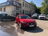 a red car parked in front of a building with cars parked in front of it