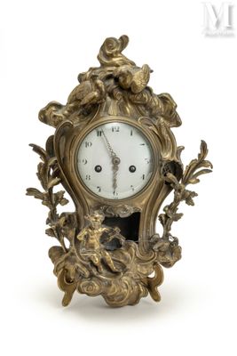 une horloge en or posée sur une surface blanche