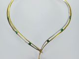 un collier en or et émeraudes orné d'une pierre verte de forme carrée