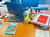 un bureau sur lequel se trouvent un ordinateur, un clavier, des livres et d'autres objets