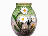 un vase avec des fleurs peintes dessus, posé sur une table