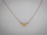un collier avec un papillon doré sur fond blanc
