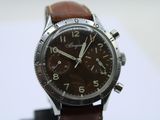 a close up of a watch with a brown leather strap