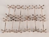 silver plated beads are arranged in a row on a white surface