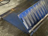 un banc bleu posé sur un sol métallique