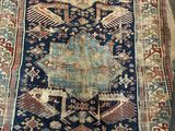 an old rug is laying on the floor next to a chair