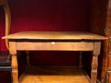 a wooden table with a shelf underneath it on a red carpet