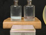 three glass bottles sitting on a wooden stand next to a clock