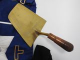 a blue and white uniform with a wooden spatula on it
