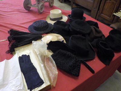 many hats and gloves on a table with a red table cloth