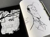 an open book with a drawing of a man in a suit