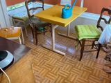 a yellow table and chairs in a room with orange walls