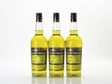 three bottles of whisky sitting next to each other on a white surface