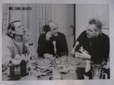 photographie en noir et blanc d'un groupe de personnes assises autour d'une table