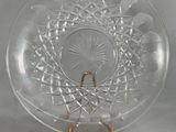 a clear glass plate with a gold handle on a table