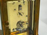 a gold clock that is sitting on a white surface