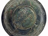 a close up of a metal bowl with a design on it