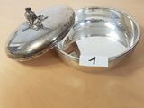 un petit bol en argent avec un couvercle posé sur une table