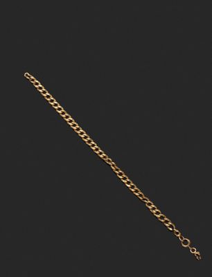 gros plan d'un bracelet en chaîne en or sur fond noir
