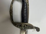 a close up of a sword on a white surface