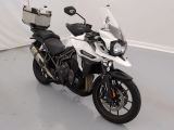 une moto blanche garée dans une pièce aux murs blancs