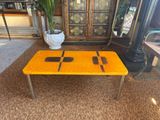 yellow coffee table with black squares on it in a living room