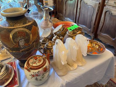 une table sur laquelle sont disposés de nombreux plats et vases