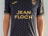 Cet homme pose pour une photo dans son maillot de foot