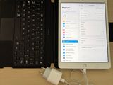 a laptop and a tablet on a table with a charger