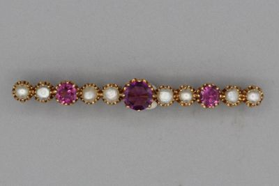 un gros plan sur un bracelet violet et blanc orné de perles