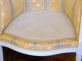 a white chair with a yellow striped seat and a beige cushion