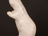 a white marble sculpture of a rat on a wooden base