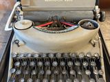 an old typewriter sitting on top of a table next to a box