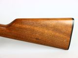 a close up of a wooden rifle on a white surface